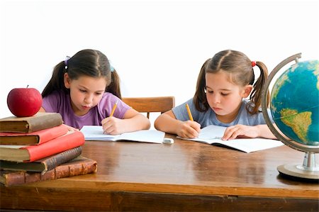 simsearch:400-08315791,k - two girls pupils sitting by the table with globe and red apple on a pile of books, Isolated on white Foto de stock - Super Valor sin royalties y Suscripción, Código: 400-04982098