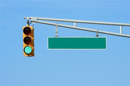 Green traffic signal light with sign on blue sky Stock Photo - Budget Royalty-Free & Subscription, Code: 400-05007764