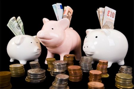 Piggybank with various international currencies on a black background. Three pigs are showing the 3 major international currencies, Dollar, Euro and Pound Stirling. Dollar is in the smaller pig conceptualizing the weak currency. Foto de stock - Super Valor sin royalties y Suscripción, Código: 400-05008206