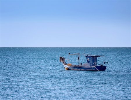 A small old wooden fishing boat anchored in the bay Foto de stock - Super Valor sin royalties y Suscripción, Código: 400-05017287