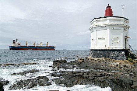 simsearch:400-04272525,k - Lighthouse, Bluff, New Zealand with container ship being guided out of the harbor area Stock Photo - Budget Royalty-Free & Subscription, Code: 400-05011715