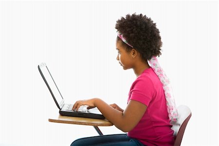 simsearch:400-05012508,k - Side view of African American girl sitting in school desk typing on laptop computer. Foto de stock - Super Valor sin royalties y Suscripción, Código: 400-05012503