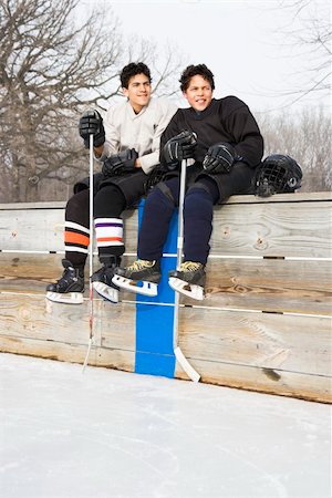 Two boys in ice hockey uniforms sitting on ice rink sidelines looking and smiling. Stock Photo - Budget Royalty-Free & Subscription, Code: 400-05013488