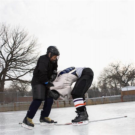 Ice hockey player boy roughing up another player on the ice rink. Stock Photo - Budget Royalty-Free & Subscription, Code: 400-05013489