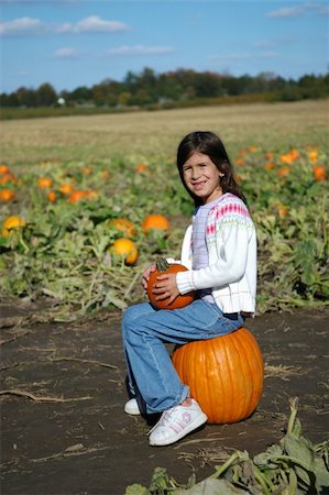 Girl in a pumpkin patch sitting and smiling. Stock Photo - Budget Royalty-Free & Subscription, Code: 400-05013745