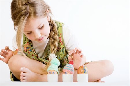 preteen girl feet - Studio portrait of a young blond girl who is checking her painted easter eggs with wool hat Foto de stock - Super Valor sin royalties y Suscripción, Código: 400-05028824
