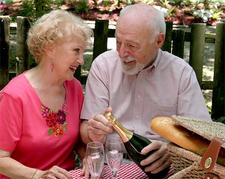 simsearch:400-04208630,k - An attractive senior couple on a picnic, looking lovingly into eachothers eyes as he opens the wine. Stock Photo - Budget Royalty-Free & Subscription, Code: 400-05020342