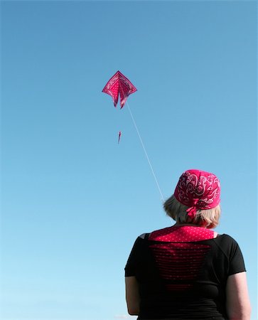 sky in kite alone pic - A woman in a bandana flies a kite of the same style Foto de stock - Super Valor sin royalties y Suscripción, Código: 400-05036207