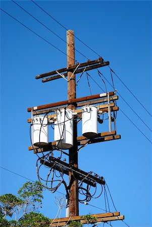 Three Transformers connected to three lines secured to a telephone pole as electricity surges through the wires generating power meeting the demand for consumers of utility. Photographie de stock - Aubaine LD & Abonnement, Code: 400-05030871