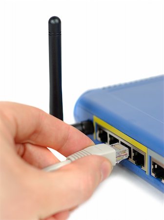 Male hand plugging connector into wifi router isolated over white Foto de stock - Super Valor sin royalties y Suscripción, Código: 400-05049421