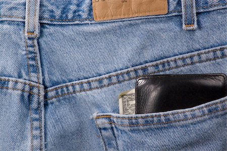 Closeup of denim blue jeans with wallet sticking out of back pocket. The edge of a dollar bill can be seen in the wallet. Stock Photo - Budget Royalty-Free & Subscription, Code: 400-05041063