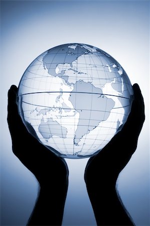 Hand holding translucent globe with blue background Stock Photo - Budget Royalty-Free & Subscription, Code: 400-05041406