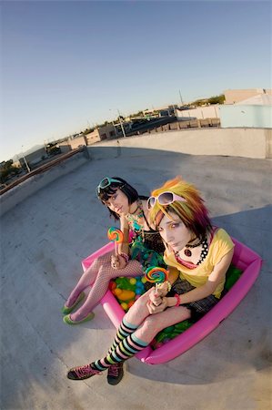 simsearch:400-04016564,k - Fisheye shot of girls in brightly colored clothing in a plastic pool on a roof with sunglasses and lollipops Stock Photo - Budget Royalty-Free & Subscription, Code: 400-05053735