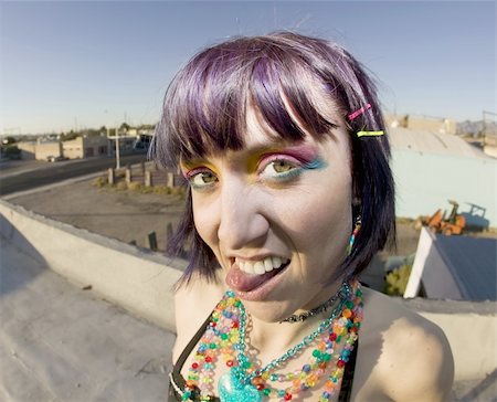 simsearch:400-04016564,k - Fisheye shot of young woman sticking out her tongue on a roof Stock Photo - Budget Royalty-Free & Subscription, Code: 400-05053754