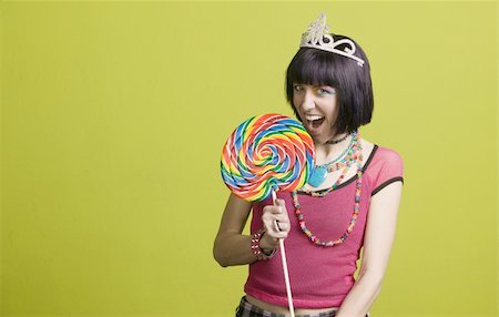simsearch:400-04016564,k - Pretty young woman takes a bite from a large lollipop Stock Photo - Budget Royalty-Free & Subscription, Code: 400-05053812