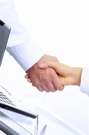 simsearch:400-04609965,k - view of handshake over paper and computer in the background Stock Photo - Budget Royalty-Free & Subscription, Code: 400-05062287