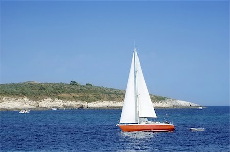 Red sailboat sailing between small islands Stock Photo - Budget Royalty-Free & Subscription, Code: 400-05076659