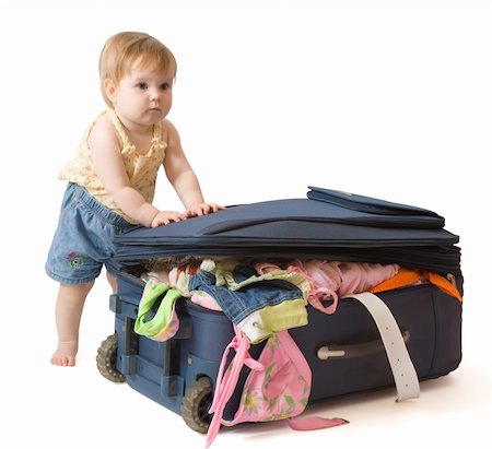 Baby girl standing near the suitcase, trying to pack it, isolated, with clipping path Stock Photo - Budget Royalty-Free & Subscription, Code: 400-05078166