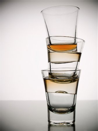 simsearch:400-04558755,k - A pile of three almost empty shots of whisky on white background over gray floor Stock Photo - Budget Royalty-Free & Subscription, Code: 400-05072272