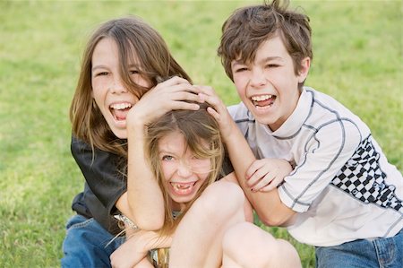 Three young siblings wrestling outdoors on the grass Foto de stock - Super Valor sin royalties y Suscripción, Código: 400-05073579