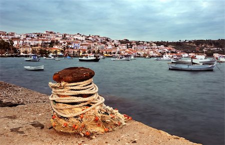 Picture of the seaside town of Koroni, in southern Peloponnese, Greece, showing a bollard in the foreground. Boats show some motion blur from long exposure Stock Photo - Budget Royalty-Free & Subscription, Code: 400-05088016
