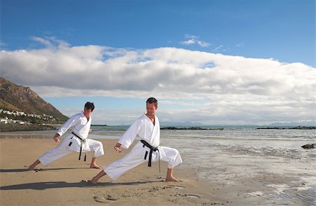 Young adult men with black belt practicing a Kata on the beach on a sunny day Stock Photo - Budget Royalty-Free & Subscription, Code: 400-05083176