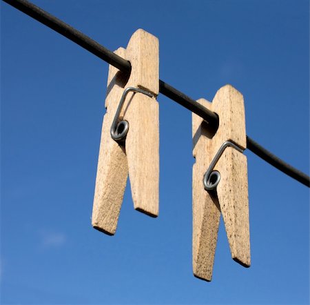 peg - Two wooden clothes-peg hang a rope on sky background Stock Photo - Budget Royalty-Free & Subscription, Code: 400-05098178