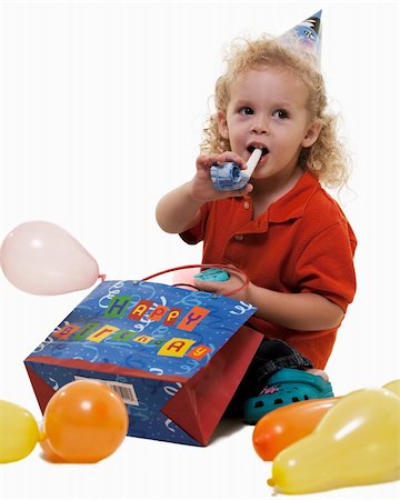 simsearch:400-04847852,k - Adorable little three year old boy wearing party hat sitting with balloons blowing on a party favor Stock Photo - Budget Royalty-Free & Subscription, Code: 400-05098794