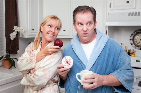 simsearch:400-05106591,k - Couple in Kitchen Eating Donut and Coffee or Healthy Fruit. Stock Photo - Budget Royalty-Free & Subscription, Code: 400-05106585