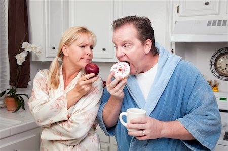 simsearch:400-05106591,k - Couple in Kitchen Eating Donut and Coffee or Healthy Fruit. Stock Photo - Budget Royalty-Free & Subscription, Code: 400-05106586