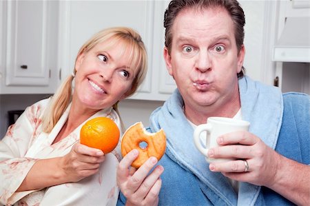 simsearch:400-05106591,k - Couple in Kitchen Eating Donut and Coffee or Healthy Fruit. Stock Photo - Budget Royalty-Free & Subscription, Code: 400-05106589