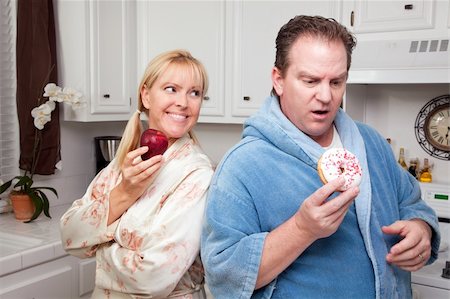 simsearch:400-05106591,k - Couple in Kitchen Eating Donut and Coffee or Healthy Fruit. Stock Photo - Budget Royalty-Free & Subscription, Code: 400-05106583