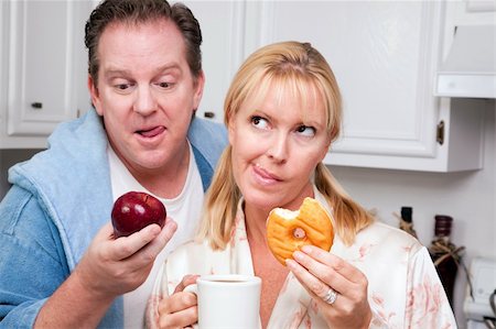 simsearch:400-05106591,k - Couple in Kitchen Eating Donut and Coffee or Healthy Fruit. Stock Photo - Budget Royalty-Free & Subscription, Code: 400-05106594
