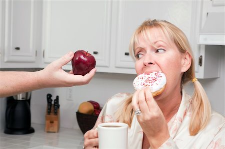 simsearch:400-05106591,k - Couple in Kitchen Eating Donut and Coffee or Healthy Fruit. Stock Photo - Budget Royalty-Free & Subscription, Code: 400-05106592