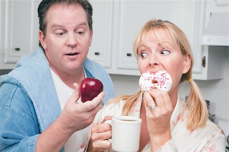 simsearch:400-05106591,k - Couple in Kitchen Eating Donut and Coffee or Healthy Fruit. Stock Photo - Budget Royalty-Free & Subscription, Code: 400-05106593