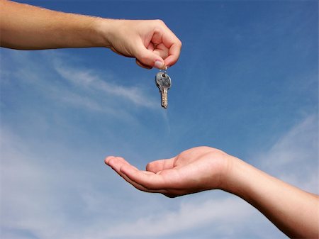 finger holding a key - Hands with key on a background sky Stock Photo - Budget Royalty-Free & Subscription, Code: 400-05106825