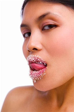 Young Asian lady licking her lips covered with granulated sugar with sensual looking Stock Photo - Budget Royalty-Free & Subscription, Code: 400-05117241