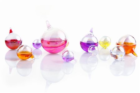 set of glass containers filled with colored liquid reflecting in a white surface Stock Photo - Budget Royalty-Free & Subscription, Code: 400-05110033