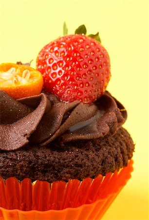 simsearch:400-04764403,k - Miniature chocolate cupcake with icing, fresh strawberry and orange rind on yellow background Stock Photo - Budget Royalty-Free & Subscription, Code: 400-05125455