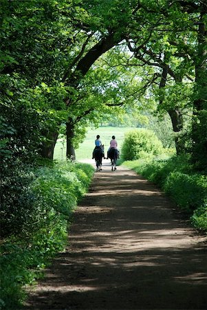 Two girls riding down a country lane Stock Photo - Budget Royalty-Free & Subscription, Code: 400-05136117