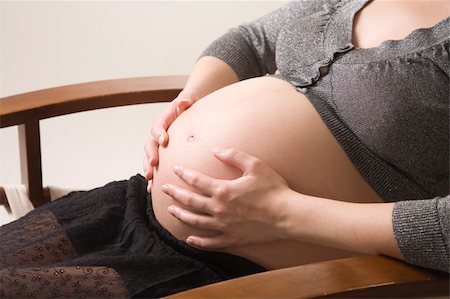 simsearch:400-04396054,k - belly of pregnant woman in chair in studio Stock Photo - Budget Royalty-Free & Subscription, Code: 400-05139319