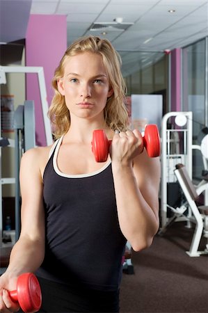 nice blond girl in a fitness club making exercise at mirror with dumb-bell Stock Photo - Budget Royalty-Free & Subscription, Code: 400-05139508