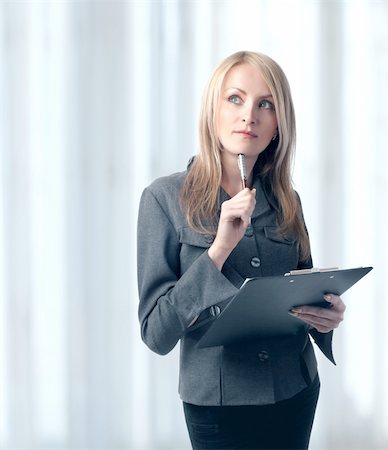 Woman holding clipboard and pen, isolated Stock Photo - Budget Royalty-Free & Subscription, Code: 400-05130026