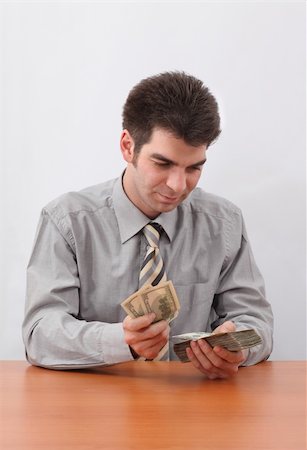 simsearch:400-04529024,k - Young businessman counting US paper currency with sitting at the table. Stock Photo - Budget Royalty-Free & Subscription, Code: 400-05130123