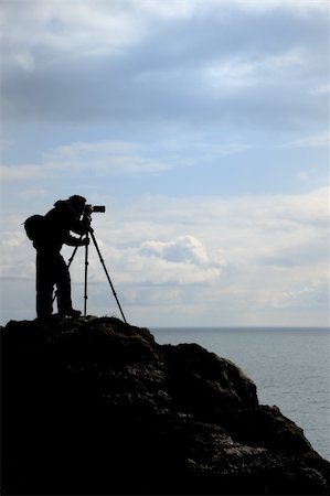 The photographer on mountain. A silhouette of the person with the camera on a background of the sky Stock Photo - Budget Royalty-Free & Subscription, Code: 400-05130892