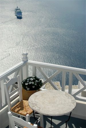 simsearch:649-02054287,k - View across a balcony with table and chairs, looking down over the caldera in Santorini, where a cruise ship has arrived Stock Photo - Budget Royalty-Free & Subscription, Code: 400-05144117