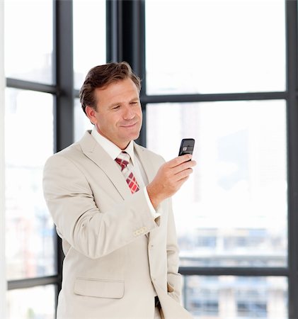 phone one person adult smile elderly - Portrait of a mature businessman sending a message on his cell-phone Stock Photo - Budget Royalty-Free & Subscription, Code: 400-05145011