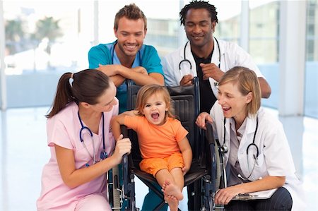 doctor consulting patient in hospital room - Group of doctors playing with a baby in a wheelchair Stock Photo - Budget Royalty-Free & Subscription, Code: 400-05145049