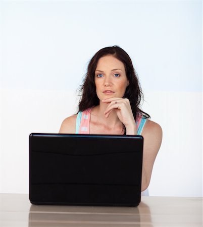 simsearch:400-05729275,k - Young woman working with her laptop looking at the camera Stock Photo - Budget Royalty-Free & Subscription, Code: 400-05147053