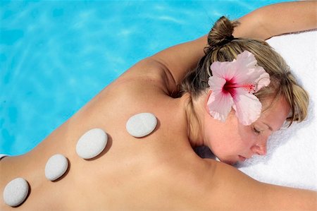 simsearch:400-05318677,k - Woman with massage stones by a blue pool Stock Photo - Budget Royalty-Free & Subscription, Code: 400-05143631